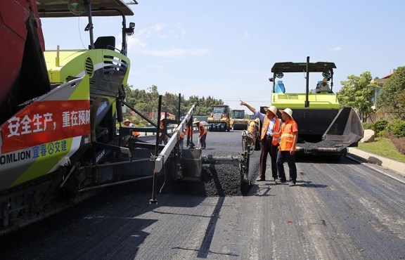 攤鋪機(jī)、壓路機(jī)等設(shè)備緊張有序運(yùn)行，高達(dá)170℃的瀝青混合料炙烤著公路人